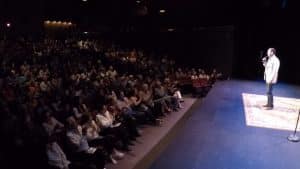 Shaun Eli on stage at a theatre